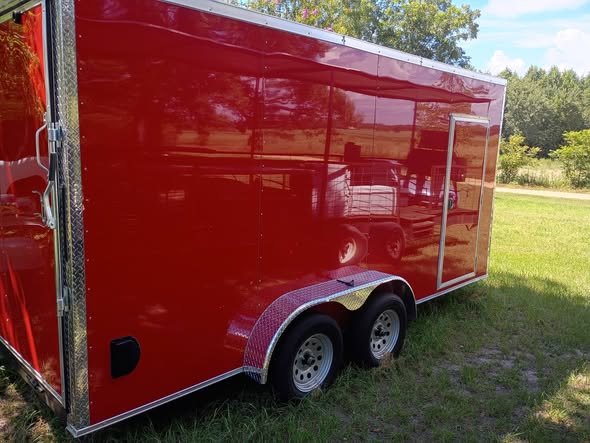 The red J-Hugh Farms trailer parked on the grass